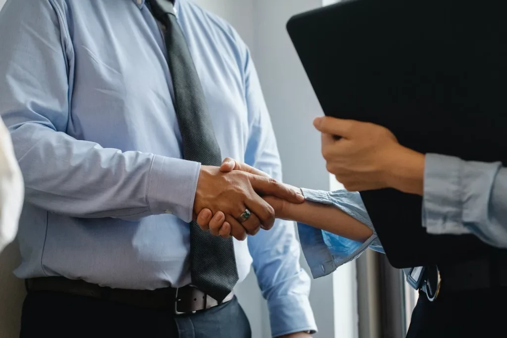 Man and woman shaking hands in office
