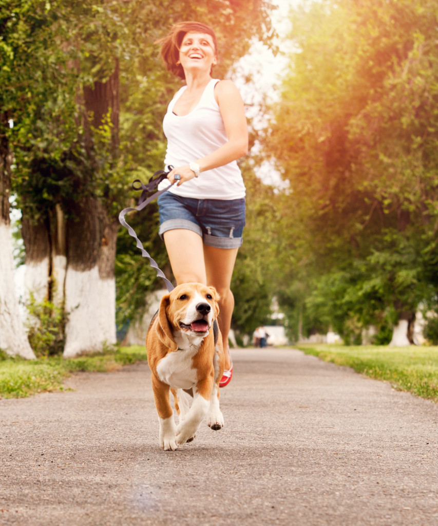 a woman running with a dog
