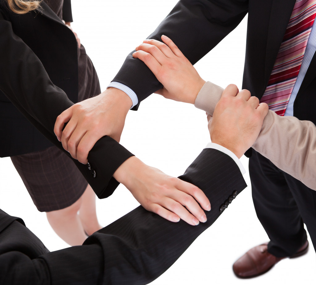 A group of people linking hand together
