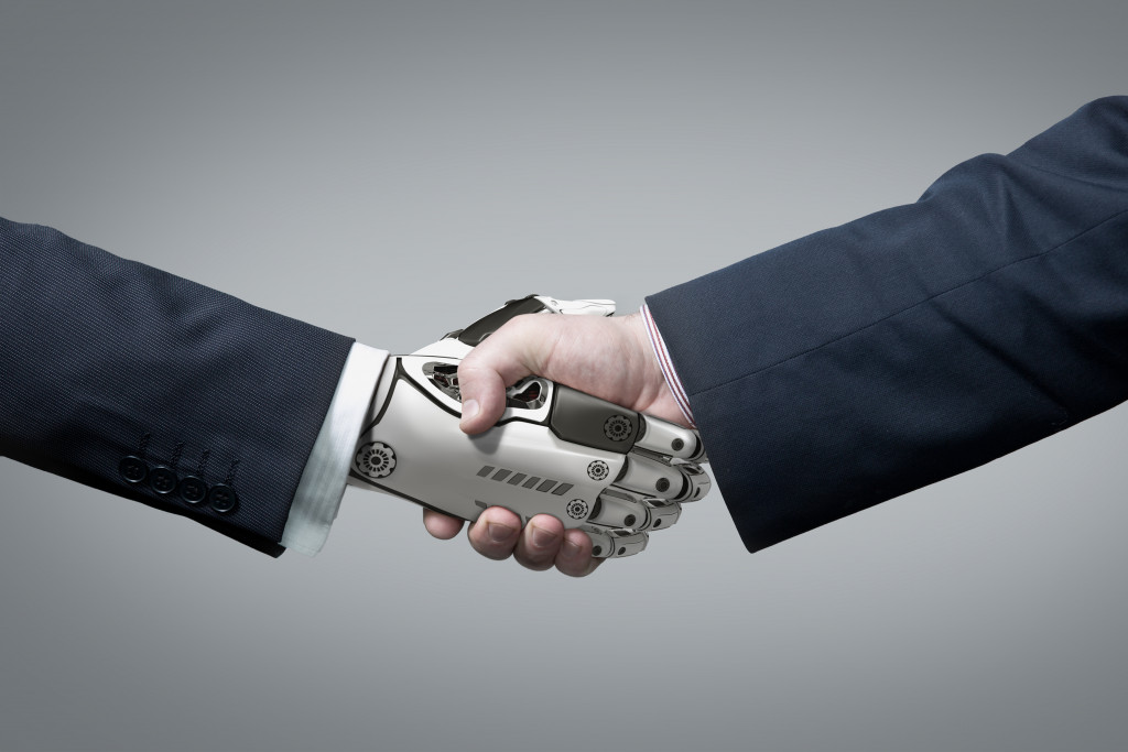 robot hand shaking hands with business hand