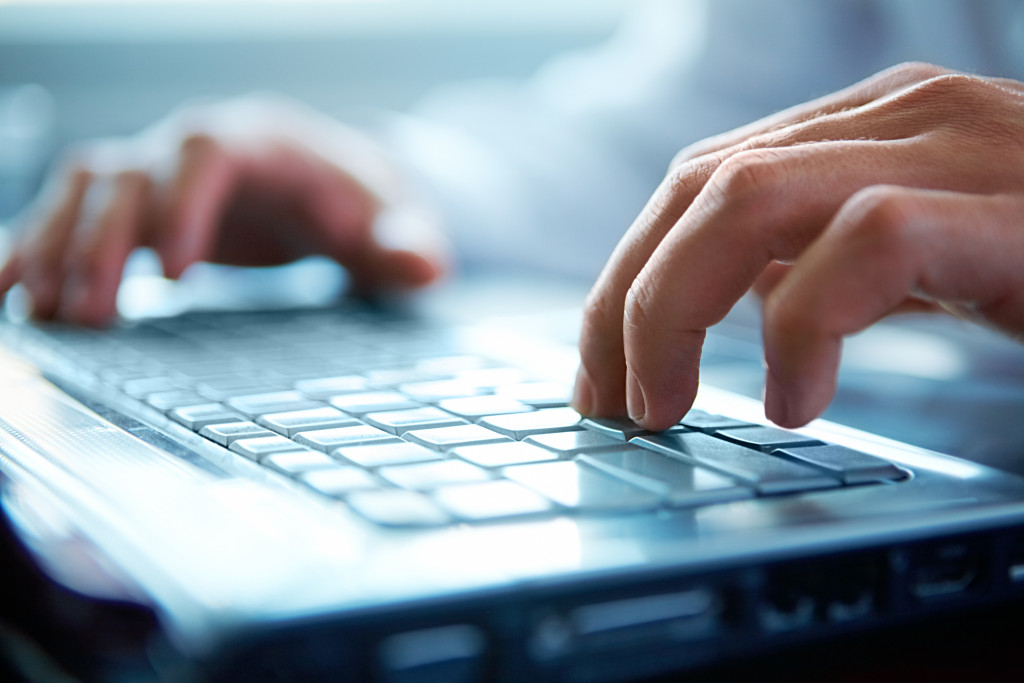 A person's hands typing on a keyboard